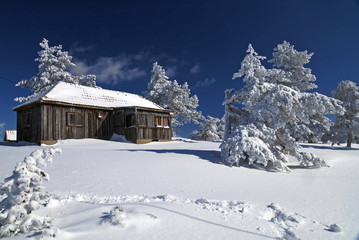 Mountain house in snow, winter sunny day