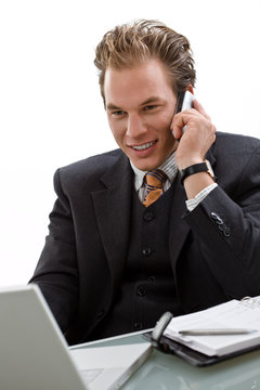 Businessman using laptop computer, mobile phone,