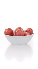 Mehrere rote Äpfel in Schale vor weiß