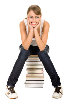 Smiling Woman Sitting On Stack Of Books