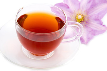 Transparent teacup with tea and flower