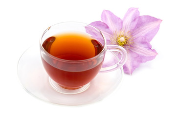 Transparent teacup with tea and flower