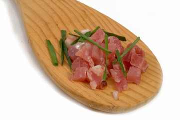 Gewürfelter Schinken-Speck auf einem Holzlöffel