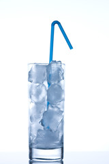 Glass with pure ice, no water, with blue straw