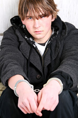 teen crime - boy with handcuffs portrait