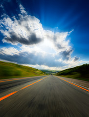 motion blurred road and cloudy blue sky