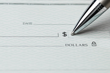 Closeup of pen writing on a blank bank check