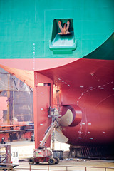 ship repairs in dry dock with screw propeller