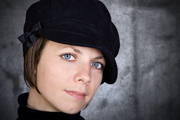 Attractive Brunette in Hat against Grunge Background