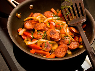 Skillet of sausage and red bell peppers on the stove