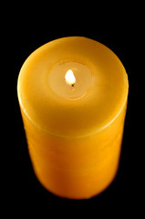 Beautiful yellow candle isolated on black background