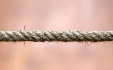 Closeup detail of a rope over a warm background.