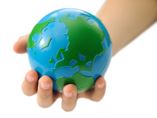 Earth in a children's hand isolated on a white background