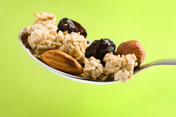 spoon with cereal, nuts and raisin