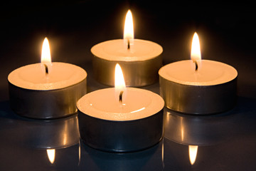 Four candles on glass