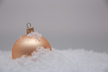 goldene Weihnachtskugel im Schnee