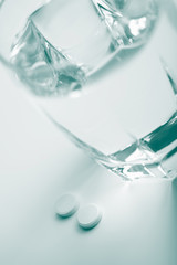 two pills and glass of water