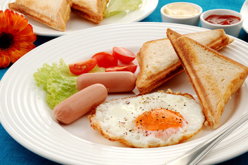 Breakfast - toasts, egg, sausage and vegetables