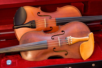 Two violins side by side in a case