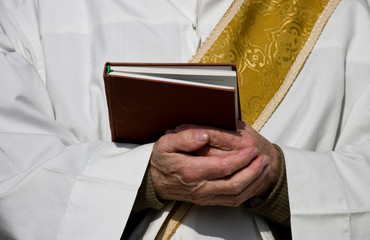 Folded hands of a priest