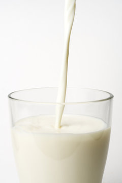 pouring fresh glass of milk isolated