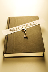 Book with golden key and success label (warm)