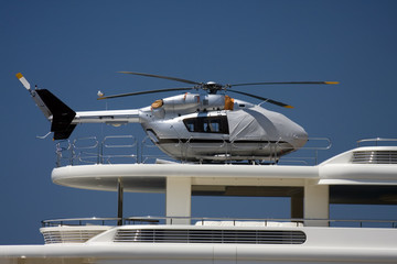 Fototapeta na wymiar Silver helicopter on yacht heliopad