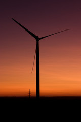 Fototapeta na wymiar Windmill against dramatic sky covered with orange color