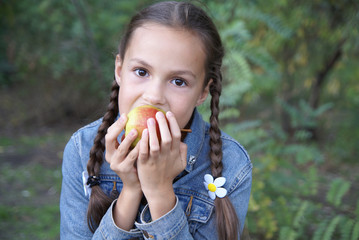 Preteen girl biting a pear