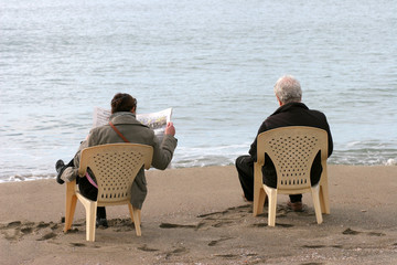 coppia seduta in riva al mare