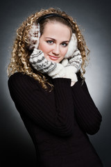 curly young woman in furs earphone and mitten