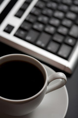 Obraz na płótnie Canvas cup of coffee and keyboard (shallow DOF)