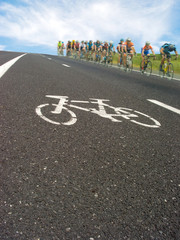Obraz premium Roadside bicycle lane mark and cyclists racing