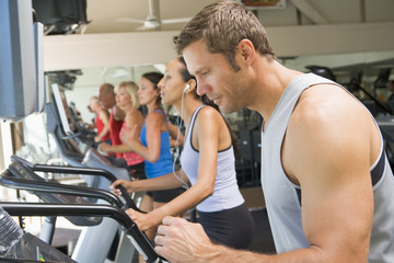 Fototapeta na wymiar Man Running On Treadmill At Gym