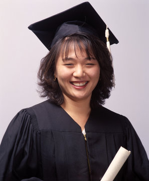 female asian college graduate with cap,gown and diploma