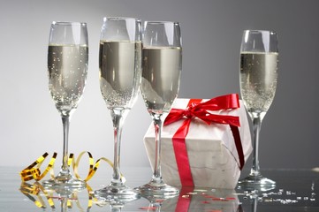 Glasses of champagne, gifts with red tapes and bows