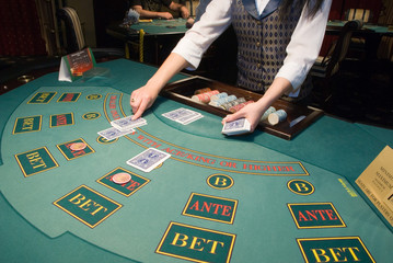 croupier handling cards at poker table