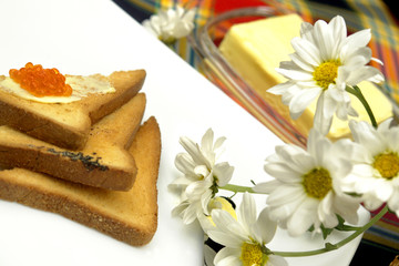 Fototapeta na wymiar Red caviar on tost with flowers