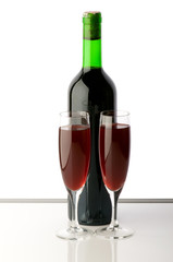 Bottle and wine glasses on reflective background