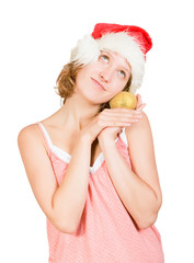 Girl in a santa clause cap with golden apple