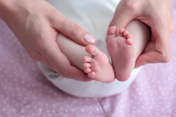 Obraz na płótnie Canvas Mother holding her baby's legs