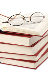 pile of books with glasses isolated