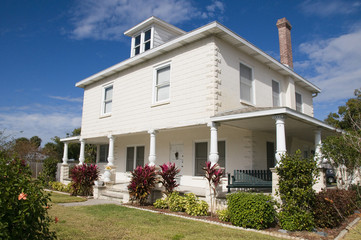 Historical home with unique porch pilars with blue sky