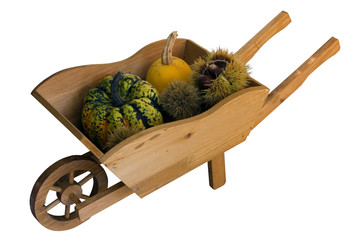 Wooden wheelbarrow with autumn fruits.