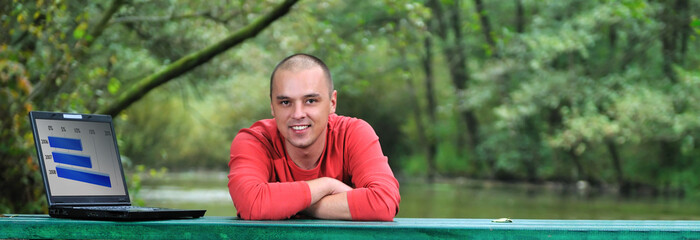 Obraz premium young businessman in red shirt working on laptop