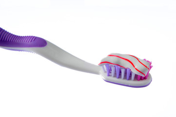 toothbrush covered by toothpaste isolated on white