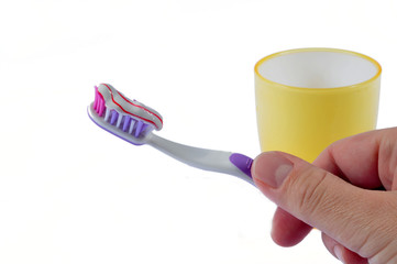 Hand handling toothbrush covered by toothpaste