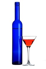 Glass with red liquid and blue bottle