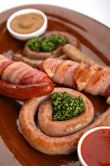 Sausages in assortment with a tomato sauce and mustard.