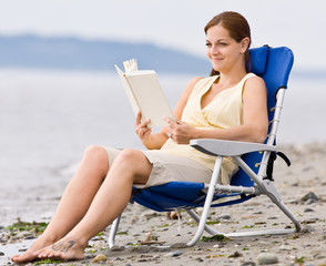 Woman reading book at beach